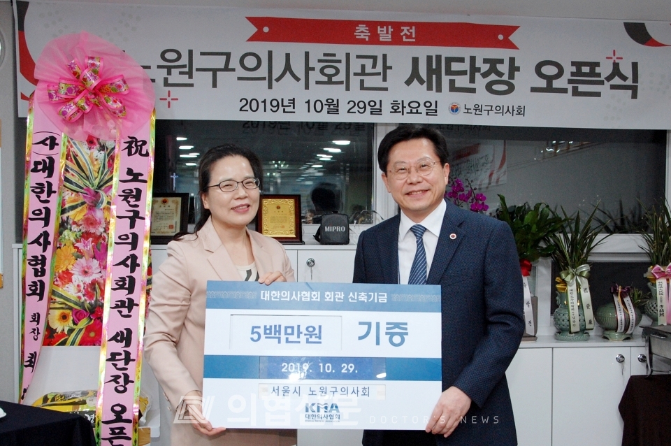 조문숙 노원구의사회장(왼쪽)이 박홍준 의협회관 신축추진위원장에게 회원들이 십시일반 마련한 신축기금 500만 원을 전하고 있다. ⓒ의협신문